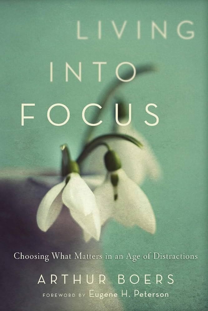 Book cover for Living Into Focus by Arthur Boers, featuring two white snowdrop flowers against a soft teal background. Subtitle reads: Choosing What Matters in an Age of Distractions.