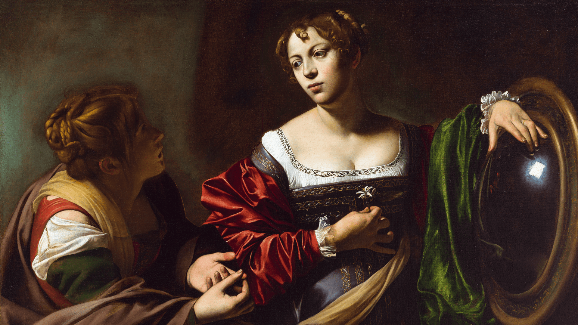 Two women in Renaissance-style clothing, one holding a mirror and gazing thoughtfully, while the other leans toward her, gesturing with her hands against a dark background.
