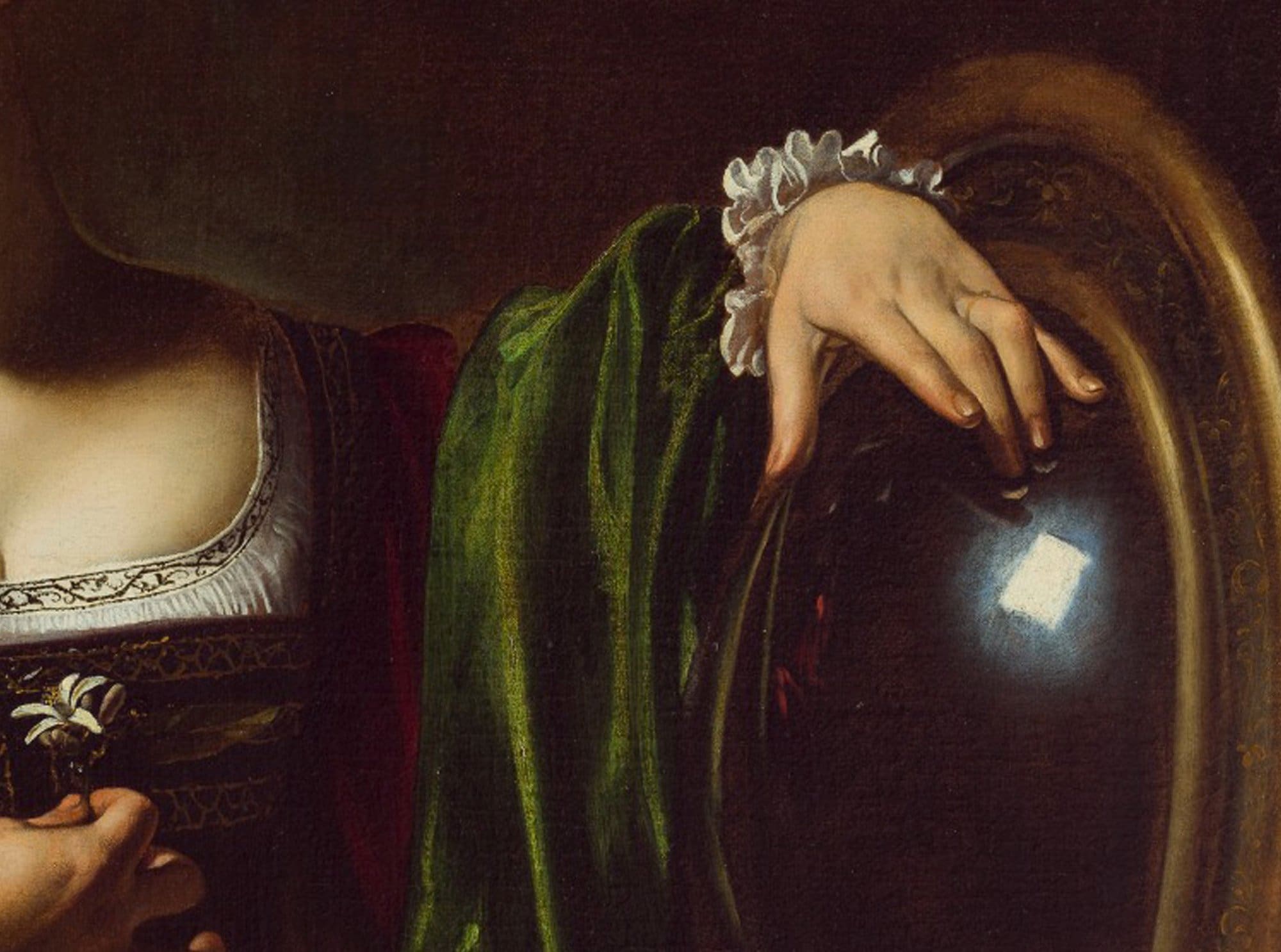 A cropped painting shows a womans hand resting on a reflective orb, wearing a green sleeve with a white ruffled cuff. She holds white flowers in her other hand, and light is reflected on the orbs surface.