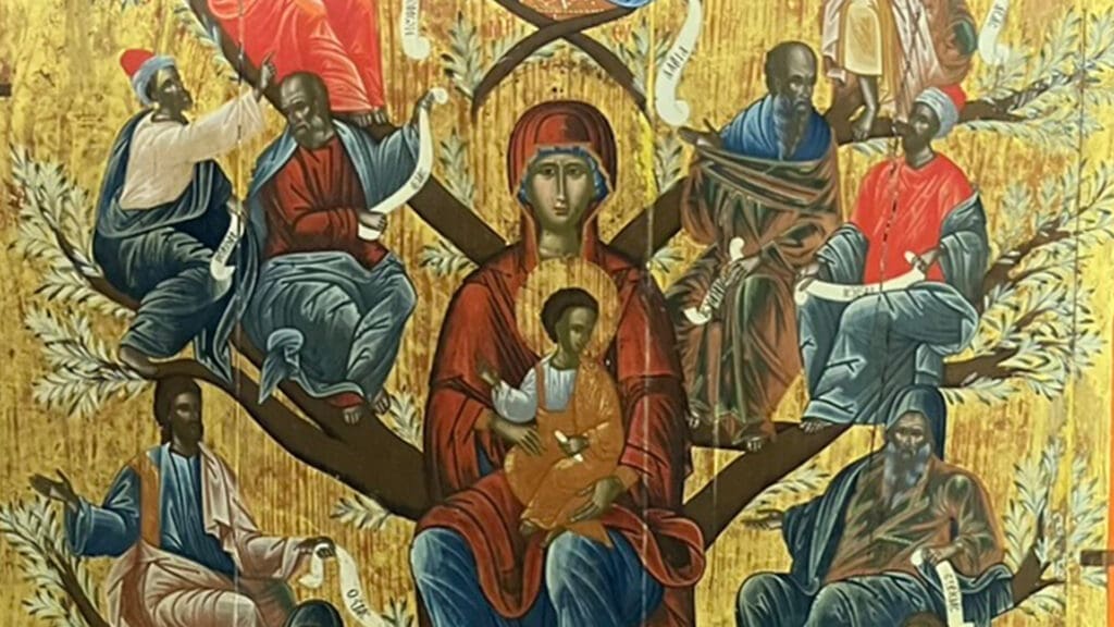A religious icon depicts the Virgin Mary holding baby Jesus at the center, surrounded by seated figures on branches of a tree, against a gold background. Each figure holds a scroll, symbolizing lineage or prophecy.