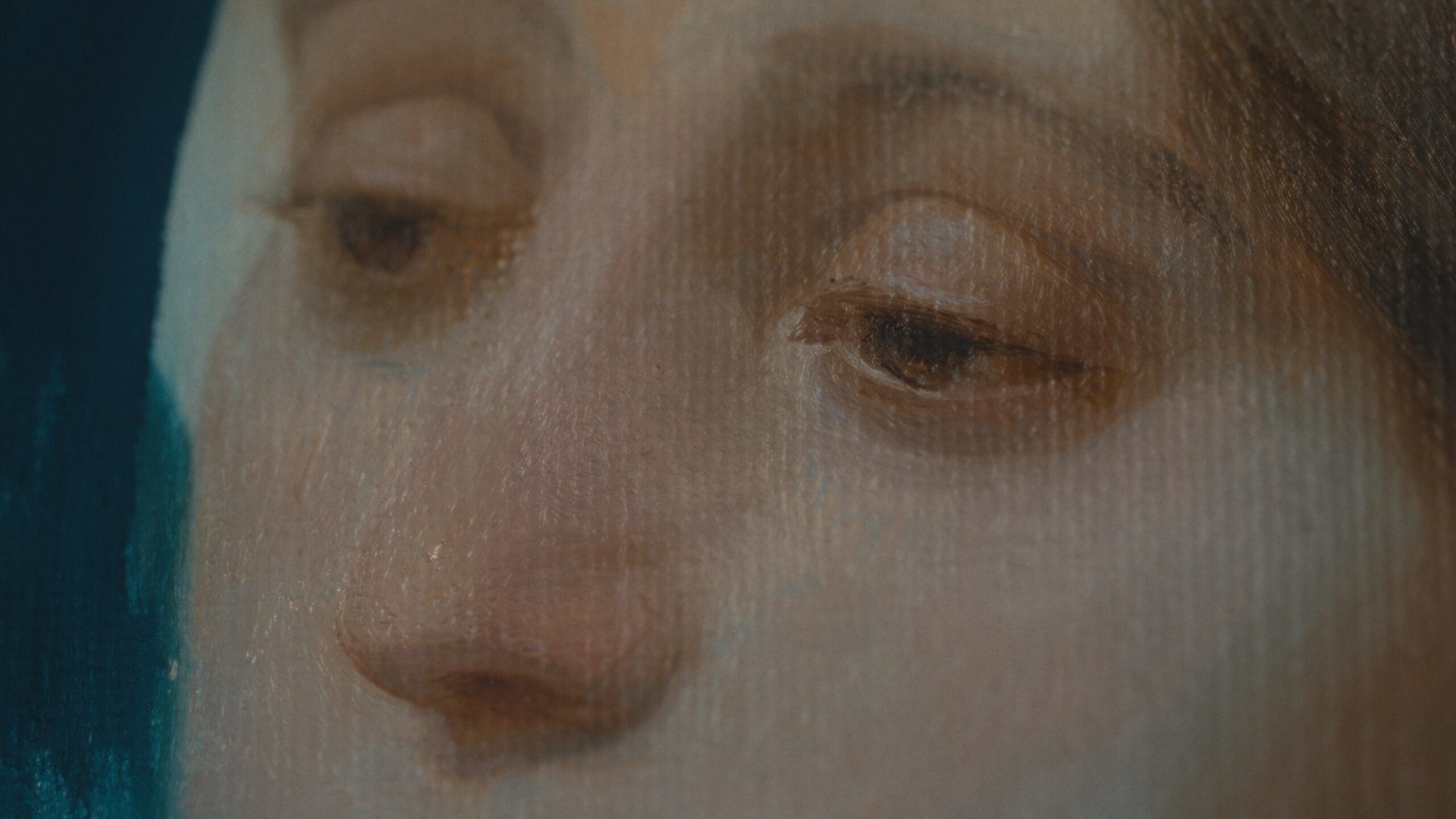 A close-up of a painted face, focusing on the eyes and nose. The brushstrokes and canvas texture are visible, highlighting the realistic and detailed artwork. The colors are soft and muted, giving a serene expression.