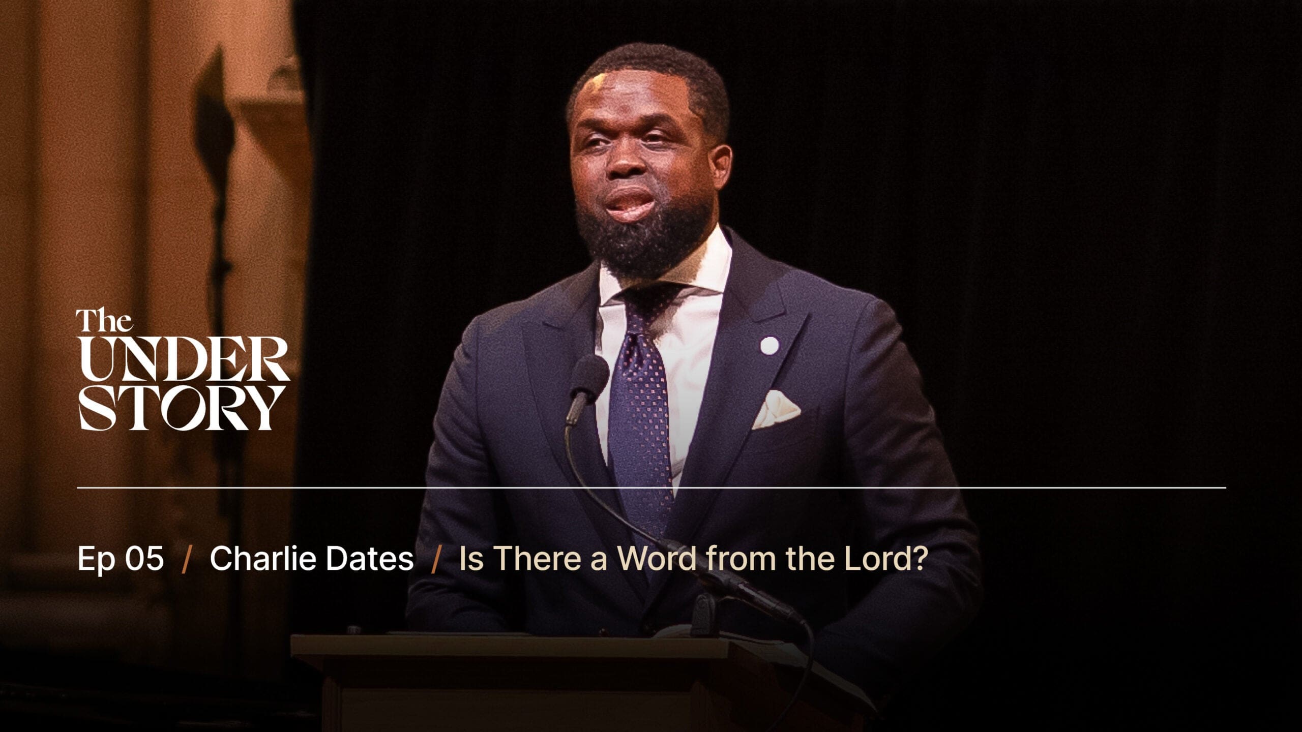A man in a dark suit and tie speaks at a podium. Text on the image reads: The Understory. Ep 05 / Charlie Dates / Is There a Word from the Lord? The background is dark with soft lighting.